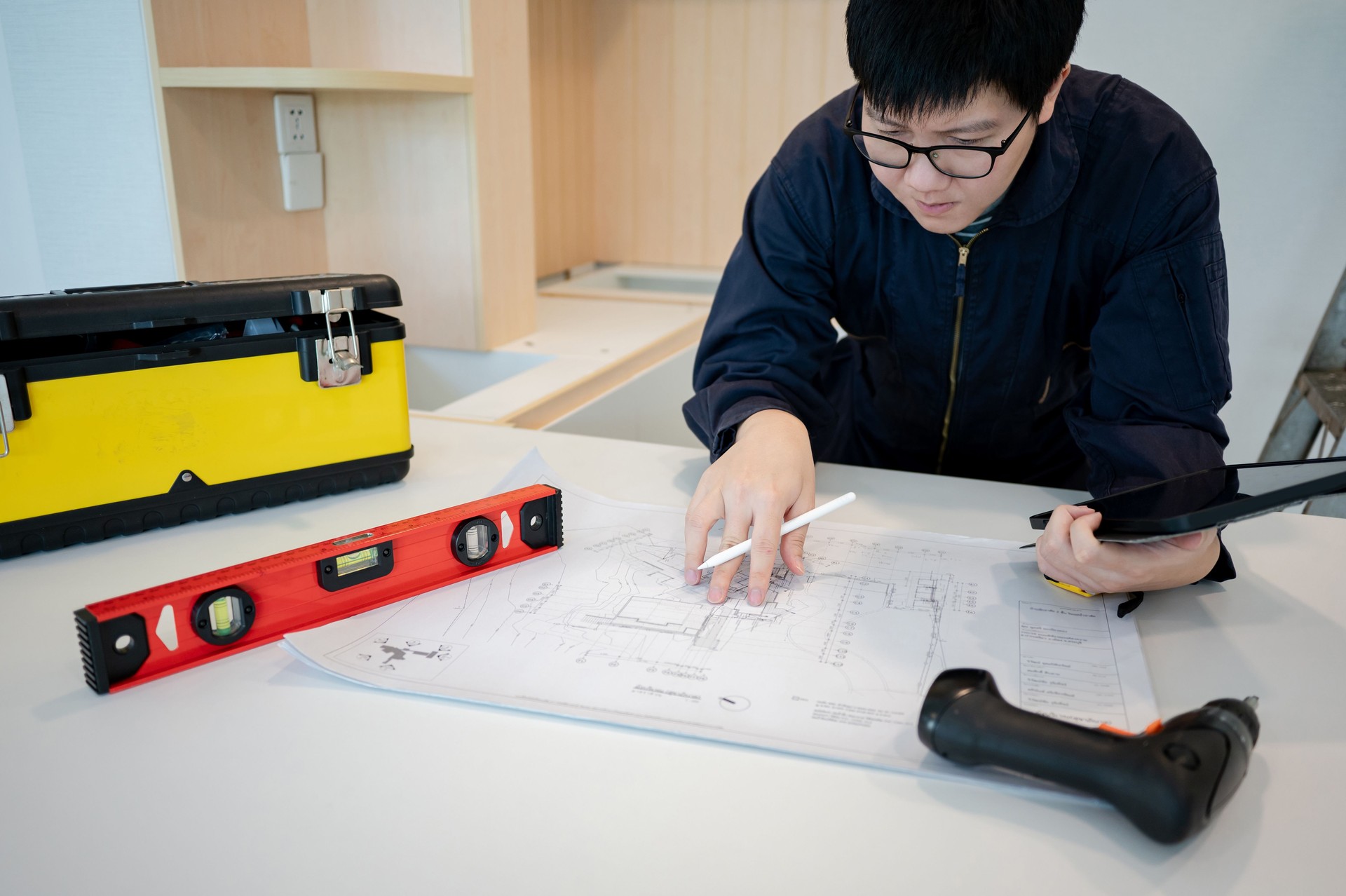 Asian male Interior worker working with architectural drawing