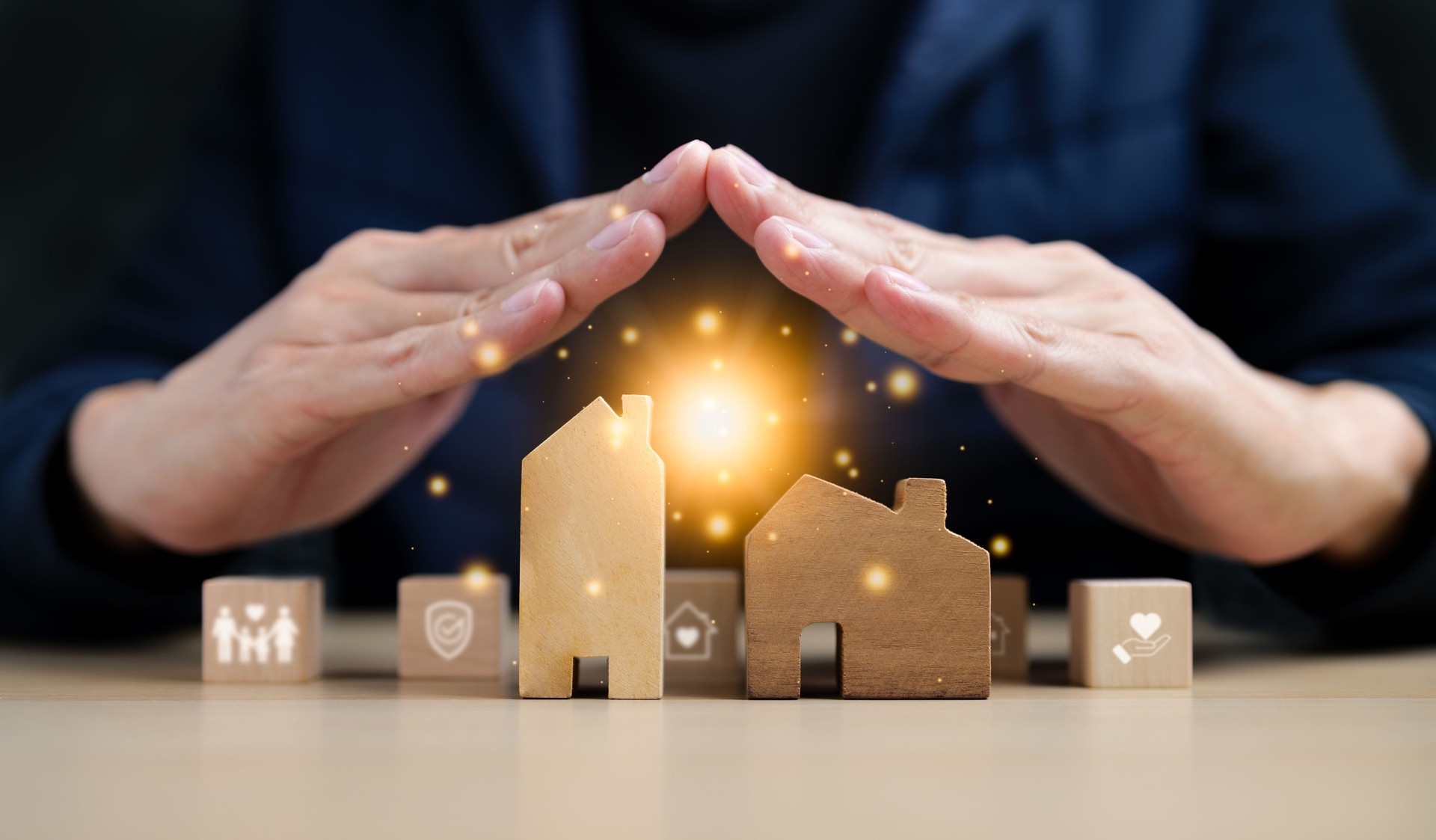 Insurance House and family health live concept. A hand covering a model of a house along with some wooden blocks. Property Insurance, Home protect insurance, care family practice, Safety estate,